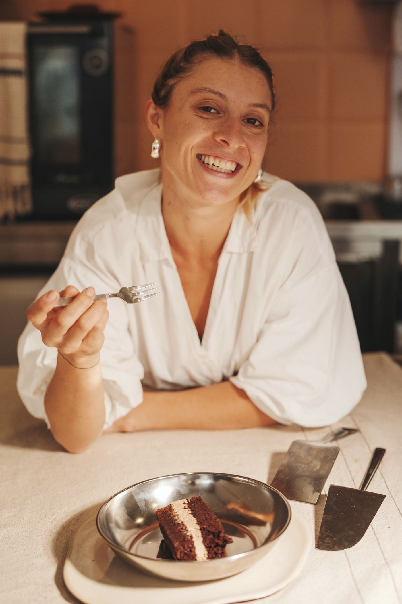Fernanda Monteiro a sorrir, à mesa com uma fatia de bolo